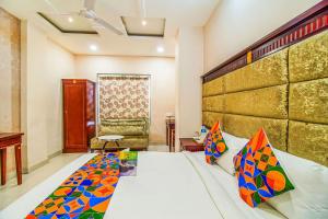 um quarto com uma cama grande e almofadas coloridas em FabHotel Eleven Heights em Bhopal