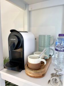 a coffee maker sitting on a shelf with dishes at Beautiful Garden Room with Private Entrance in Kingsbridge
