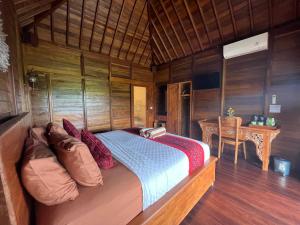 a bed in a room with a wooden wall at Mardika Private Villa in Ubud