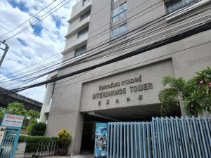 a building with a fence in front of it at Interchange Tower Serviced Apartment - SHA Extra Plus in Bangkok