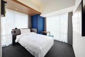 a bedroom with a white bed and blue walls at Prince Smart Inn Ebisu in Tokyo
