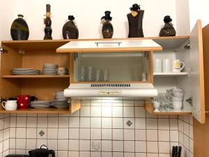 eine Küche mit Holzregalen mit Geschirr und einer Mikrowelle in der Unterkunft Ruhiges Dachgeschoß CityApartment im Zentrum Wiens in Wien
