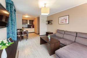 a living room with a couch and a table at VacationClub – Aquarius Apartament 99 in Kołobrzeg