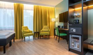 オスロにあるThon Hotel Linneのベッド、テーブル、椅子が備わるホテルルームです。