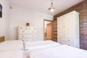 a bedroom with two beds and a brick wall at VacationClub - Plażowa 7 Apartament 2 in Gąski