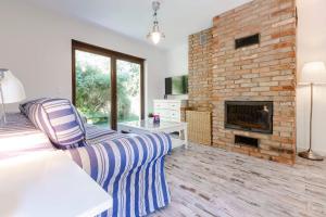 a living room with a couch and a fireplace at VacationClub - Plażowa 7 Apartament 2 in Gąski