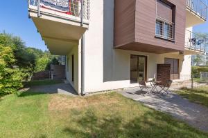 a house with two chairs and a balcony at VacationClub - Plażowa 7 Apartament 2 in Gąski