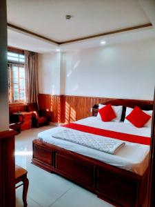 a bedroom with a large bed with red pillows at Thien Truong Hotel in Nha Trang