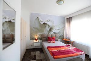 a bedroom with a bed with a painting on the wall at Hotel Sofia in Bad Wildungen