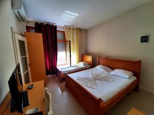 a bedroom with a bed and a television in it at Hotel Vila Giorgio in Shkodër