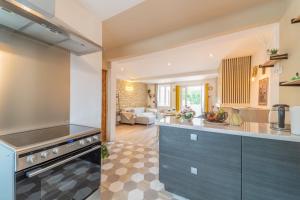una cucina con armadi blu e un soggiorno di Côté Cour, 3 chambres, terrasses, jardin privé avec terrain de pétanque, cave voutée a Corgoloin