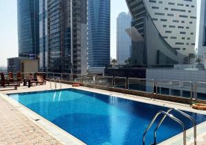 a swimming pool on top of a building with tall buildings at Hometown Apartments Trendy One Bed Apt in Ontario Tower in Dubai