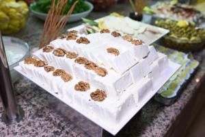 a white cake with nuts on top of it on a table at Herakles Thermal Hotel in Pamukkale