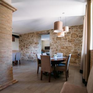 comedor con paredes de piedra, mesa y sillas en Casa Libélula - Serra da Estrela, en Covilhã