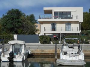 two boats docked in the water in front of a house at SUPERBE VILLA VUE MER 4 Etoiles 10 COUCHAGES PISCINE CHAUFFE in La Londe-les-Maures