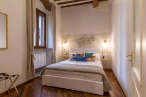 a bedroom with a large white bed with blue pillows at Casa Dora in Florence