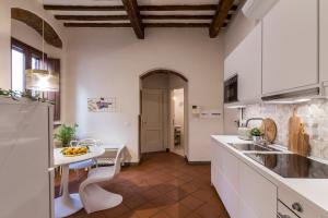 a kitchen with white cabinets and a table in it at Casa Dora in Florence