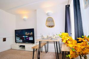 a living room with a table and a tv at Spacious 1 Bed Flat in Central Slough in Slough