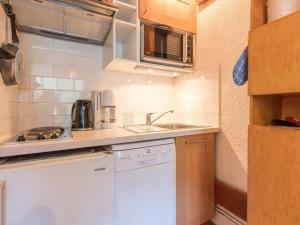 eine kleine Küche mit Spüle und Geschirrspüler in der Unterkunft Appartement Saint-Chaffrey , 1 pièce, 5 personnes - FR-1-330E-39 in Saint-Chaffrey