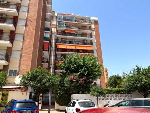 a tall building with cars parked in front of it at Apartamento Isidoro in Fuengirola
