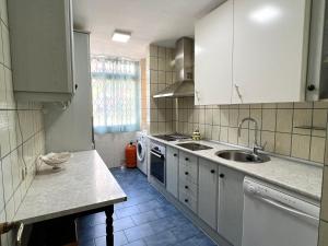 - une cuisine avec des placards blancs et un évier dans l'établissement Apartamento Isidoro, à Fuengirola