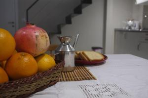 una cesta de fruta en una mesa con una manzana y naranjas en Puerta de San Juan en Sevilla