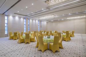 een grote kamer met tafels en gele stoelen bij The Citi Residenci Hotel - Asansol in Āsansol