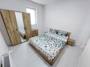 a bedroom with a bed and a mirror at Casuta cu Tei in Oradea