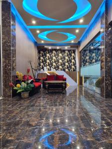 vestíbulo con sofá y techo azul en Dnaiko Syariah Hotel en Bukittinggi