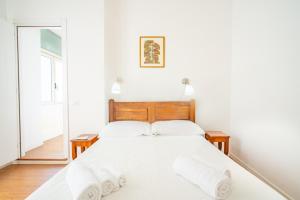 a bedroom with a bed with white sheets and pillows at Attico Luce e Colori - Terrazza Vista Mare - 5 Bdr in Cagliari