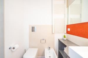a bathroom with a white toilet and a sink at Attico Luce e Colori - Terrazza Vista Mare - 5 Bdr in Cagliari