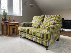 uma cadeira verde e amarela numa sala de estar em Moll’n’Cliff em Silsden