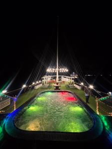 Una fuente iluminada por la noche con luces en Calypso Cruises, en Ha Long