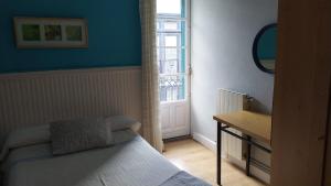 a small bedroom with a bed and a window at Pensión Manoli in Bilbao