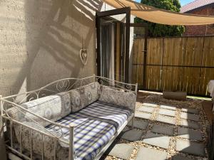 metalowa ławka siedząca na patio obok płotu w obiekcie Favour w mieście Pretoria