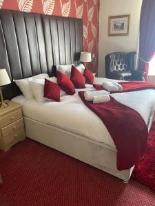 een slaapkamer met een groot bed met rode kussens bij George Hotel in Keswick