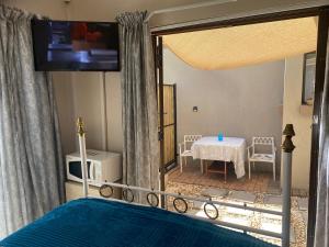 a bedroom with a bed with a view of a table at Favour in Pretoria