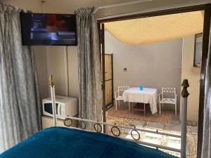 a bedroom with a bed with a view of a table at Bonzila in Pretoria