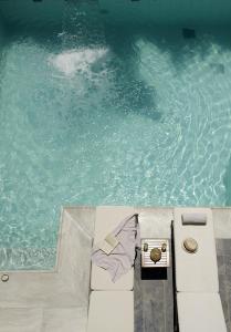 a swimming pool with a mattress next to the water at Kyma Suites Beach Hotel in Rethymno