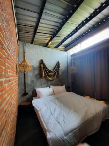 a bed in a room with a brick wall at RUMAH @ Sawah Ijen in Licin