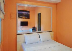 a bedroom with a large mirror above a bed at RedDoorz @ Southern Suites Guimaras in Oracon