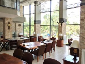 a restaurant with tables and chairs and large windows at Grand Park Hotel Corlu in Corlu