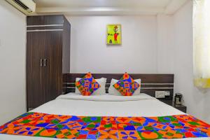 um quarto com uma cama com uma colcha colorida em FabHotel Grand Raj em Indore