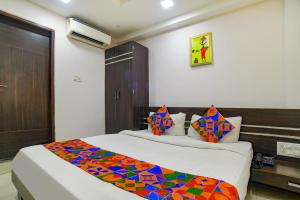 um quarto com 2 camas e um cobertor colorido em FabHotel Grand Raj em Indore