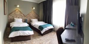 喬爾盧的住宿－Grand Park Hotel Corlu，酒店客房设有两张床和电视。