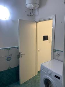 een wasruimte met een wasmachine en een deur bij Le Quattro Perle in Terrasini