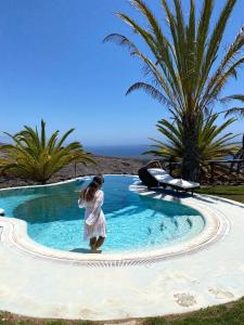 une petite fille en robe blanche debout dans une piscine dans l'établissement Villas La Gomera, à Alajeró