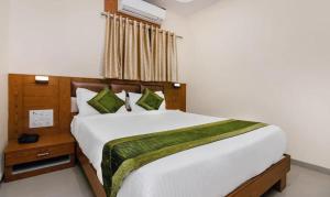 a bedroom with a large white bed and a window at Hotel Volga Plaza in Mumbai