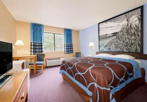 a hotel room with a bed and a desk at Super 8 by Wyndham Chariton in Chariton