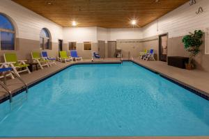 uma grande piscina num hotel com cadeiras e mesas em Days Inn by Wyndham Racine/Sturtevant em Sturtevant